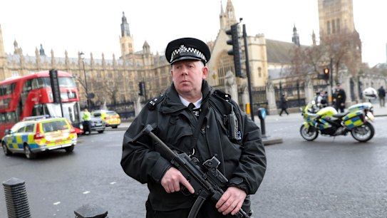 Armed officers attend to the scene outside Westminster Bridge.