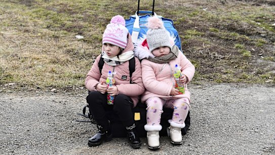 Sisters wait at a checkpoint run by local volunteers after arriving from Ukraine, crossing the border in Beregsurany, Hungary, Saturday, Feb 26, 2022. Hungary has extended legal protection to those fleeing the Russian invasion. (AP Photo/Anna Szilagyi)