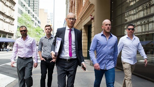 Shane Housego, Christian McDonald, Chris Sheehy and Steven Rapisarda join lawyer Nicholas Stewart (centre) to lodge papers at the NSW Civil and Administrative Tribunal in Sydney. 
