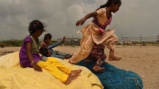 A group of children play in Tragadi Bandar, a fishing settlement on the Kutch coast, in western India. The settlement is home to over 100 families, who have been forced to change their fishing habits due to the operations of the nearby Adani power plant and port.