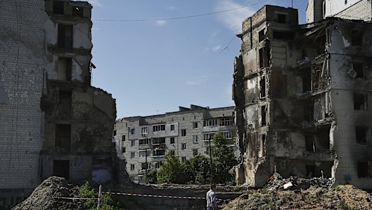 A man walks past the ruins of an apartment building complex destroyed by a Russian missile strike in the town of Borodyanka.