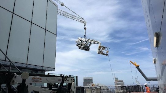 The crane dangles on top of Tower One at Barangaroo in Sydney's CBD.