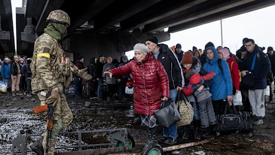 IRPIN, UKRAINE - MARCH 07: Residents of Irpin flee heavy fighting via a destroyed bridge as Russian forces entered the city on March 07, 2022 in Irpin, Ukraine. Russia continues its assault on Ukraine's major cities, including the capital Kyiv, more than a week after launching a large-scale invasion of the country. (Photo by Chris McGrath/Getty Images)