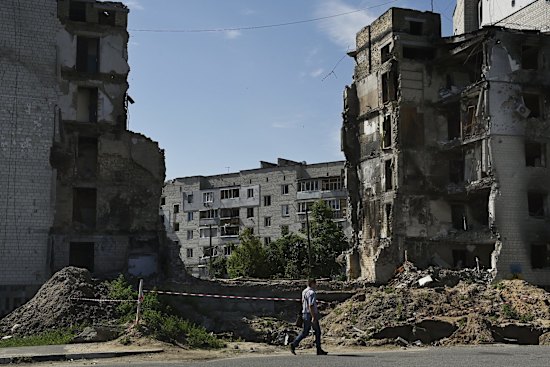 A man walks past the ruins of an apartment building complex destroyed by a Russian missile strike in the town of Borodyanka.