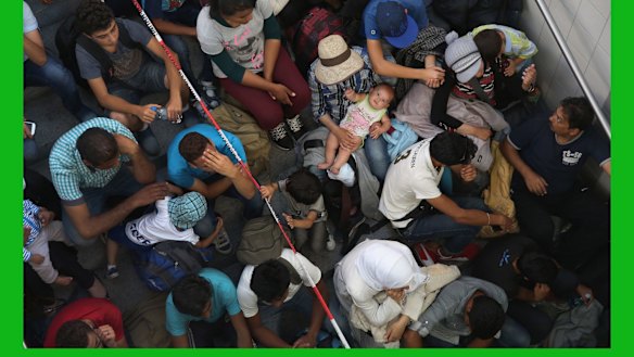 Migrants who arrived on a train from Budapest wait to be registered by the German police in Rosenheim.