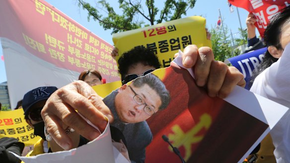 A North Korean defector tears a paper with a portrait of North Korean leader Kim Jong-un during a rally against the possible repatriation of North Korean restaurant workers to North Korea, in Seoul, last month.