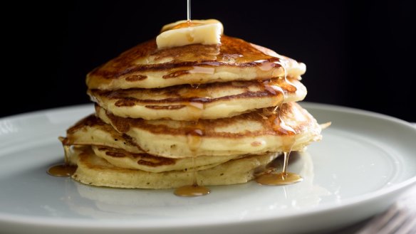 A stack of perfect buttermilk pancakes with butter and maple syrup.