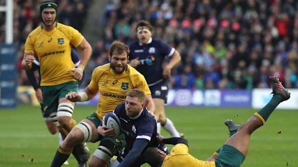 Scotland's Finn Russell is brought down by Australian players.