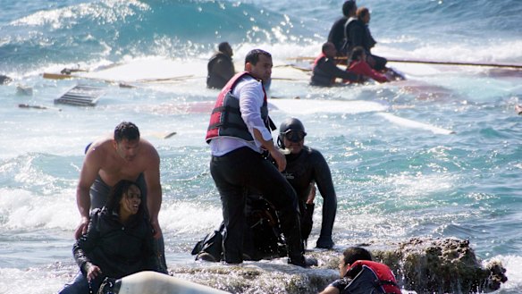 A man rescues a migrant from the Aegean, Monday, April 20. 