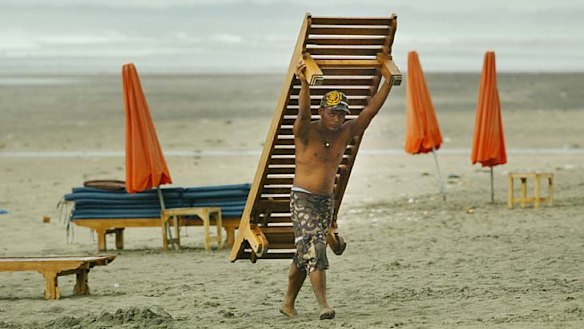 Tourist hot spot ... a man removes a  beach lounger from Kuta Beach.