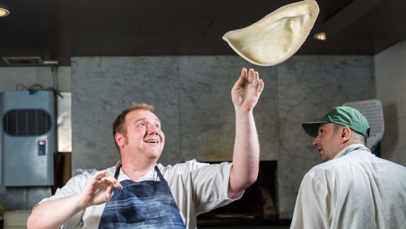 Pizza chef Alessandro Spadoni flips a dough base.