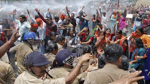 Police use a water cannon to stop demonstrators from moving towards the office of the Chief Minister.