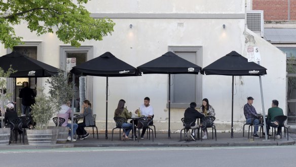 Customers sit at socially distanced tables outside a Carlton restaurant.