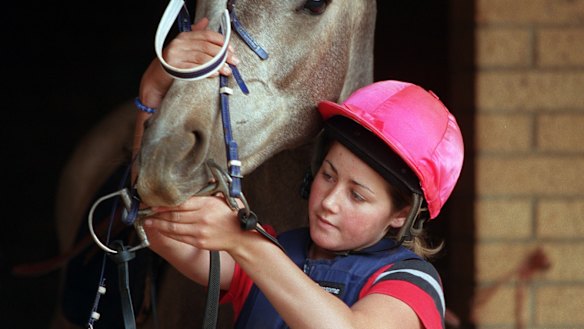 Michelle Payne putting the bridle on her horse in 2001.