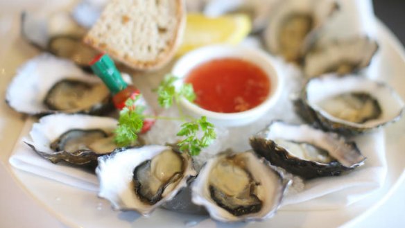 Oysters served with mignonette dressing and a miniature Tabasco bottle.