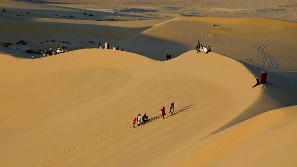 Residents walk on sand dunes near the Libyan desert oasis town of Ghadames.
