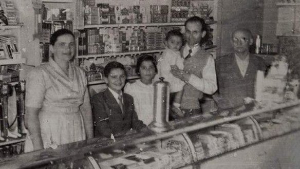 George Poulos with his family behind the counter of The Rio in its golden years. From left, Stavroula, Nik, Aphrodite, George holding Margaret and George's father, Philip. "We used to open until 11 o'clock waiting for the picture show to come out," says Nik Poulos.