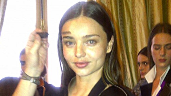 Working mum ... Miranda Kerr having her makeup touched up prior to walking the runway for Balenciaga.
