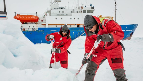 Scientists from Chris Turney’s expedition prepare a helipad as they wait to be rescued.