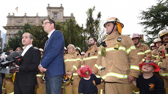 Voluntary and paid CFA members stand with Premier Daniel Andrews and new Emergency Services Minister James Merlino on Friday.
