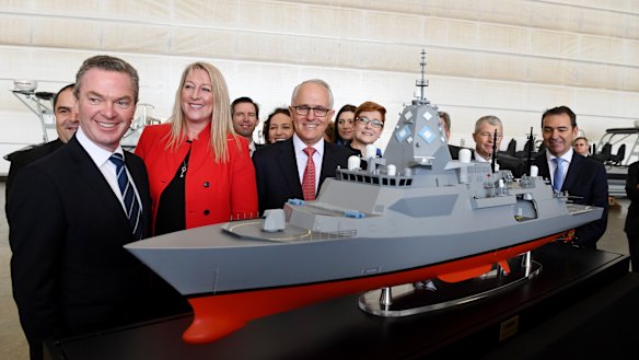 Prime Minister Malcolm Turnbull (centre), Minister for Defence Industry Christopher Pyne (left), BAE head Gabby Costigan (third left) and Navy personnel pose with a model of the new Hunter Class Frigate after the announcement of the contract in Adelaide last week.