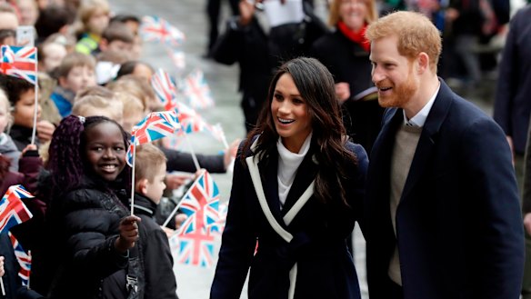 Prince Harry and his fiancee Meghan Markle are greeted by flag-waving school children in Birmingham.