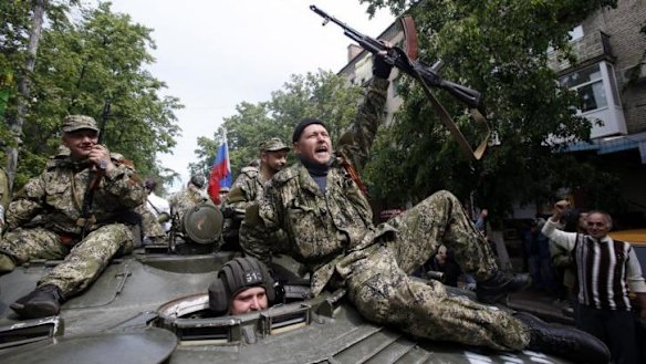 Pro-Russian gunmen atop an armored personal carrier shout slogans during a Victory Day celebration, which commemorates the 1945 defeat of Nazi Germany, in Slovyansk, eastern Ukraine.
