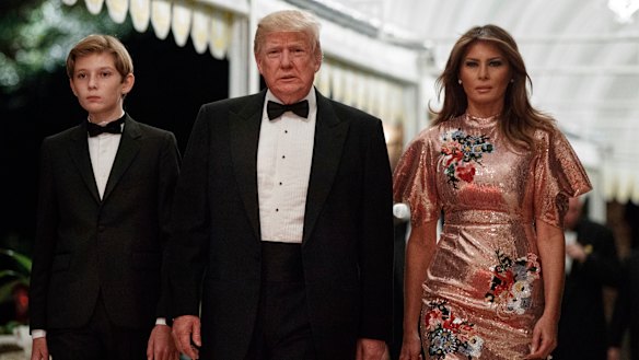 President Donald Trump arrives for a New Year's Eve gala at his Mar-a-Lago resort with first lady Melania Trump and their son Barron in Palm Beach, Florida.