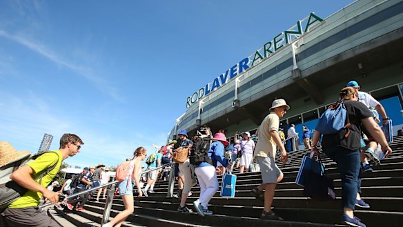 Tennis fans  rush into Rod Laver Arena on the first day of the Australian Open on Monday.