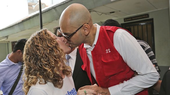 Canadian teacher Neil Bantleman, right, kisses his wife Tracy prior to the start of his trial hearing in Jakarta last year.