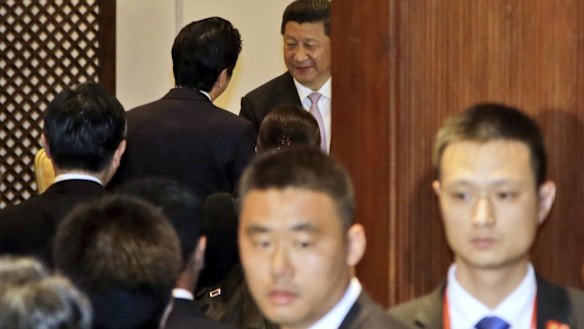 Chinese President Xi Jinping, center, greets Japan's Prime Minister Shinzo Abe on Wednesday. 