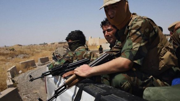 Soldiers of the Kurdish Peshmerga guard a highway adjacent to the Kirkuk Airport.
