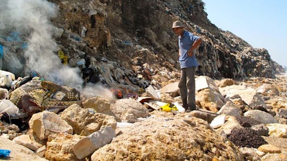 ''If only people stopped'' … Walid with his fire amid the rubbish in the illegal tip near Sidon.