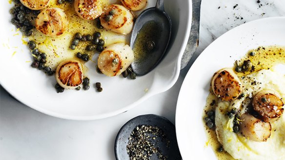Scallops served on a bed of cauliflower puree with capers and lemon.