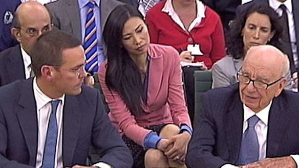 James (left) and Rupert Murdoch (right) answer questions from British politicians, with Rupert's wife Wendi (centre) watching on.