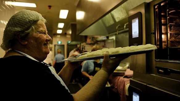 CWA volunteer Dianne Innes puts a tray of scones into the oven to cook for 16 minutes in the kitchen of the CWA tea room at the Sydney Royal Easter Show.