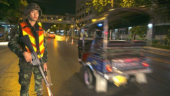 A Thai soldier stands guard at a checkpoint after a curfew started at 10pm in Bangkok, Thailand.