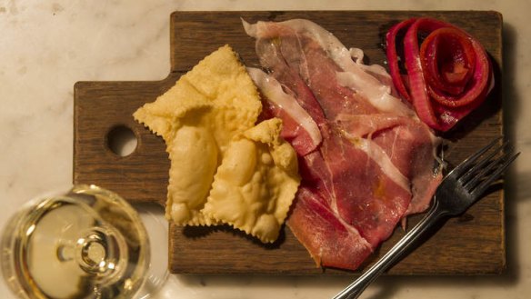 Prosciutto with gnocco fritto and pickled onion rings.