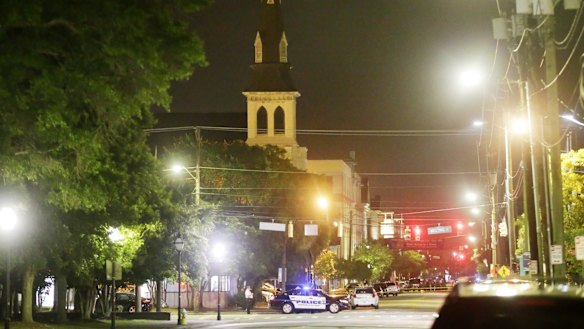 The steeple of Emanuel AME Church is visible as police close off the street after the shooting.