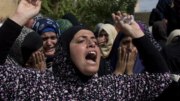 Palestinian mourners cry at the family house upon the arrival of the body of Amjad Jundi, 19, who was killed after stabbing a soldier on a bus in southern Israel.