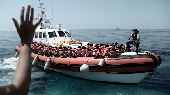 Migrants board an Italian Coast Guard ship after being transferred from the Aquarius to be taken to Spain on Tuesday.