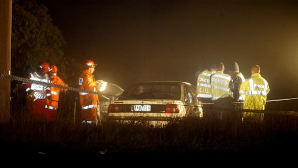 Accident or crime? Police inspect the car after it was pulled from the dam. 