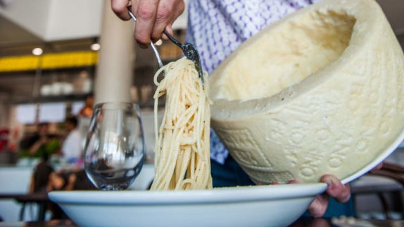 Spaghetti cacio e pepe served in a cheese wheel.