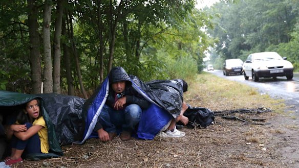 Migrants from Syria rest on the side of a road near Asotthalom, Hungary.