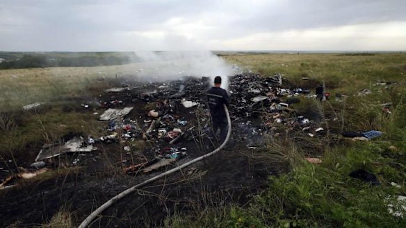 Emergencies Ministry member works at putting out a fire at the crash site.