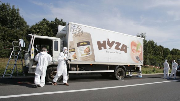 Forensic police officers inspect the truck parked on an Austrian highway.