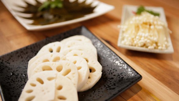 Sides include seaweed, lotus root (front) and enoki mushrooms (right).