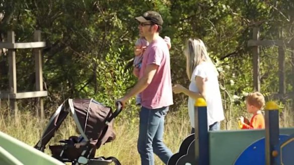 A "traditional" couple is seen walking in a playground with children.