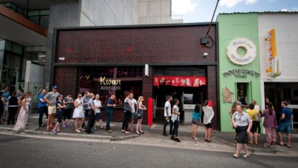 A hole lot of fans: Doughnut-lovers queue outside the Doughnut Time hole-in-the-wall.