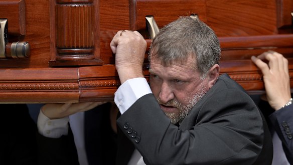 Greg Hughes carries his son's casket.